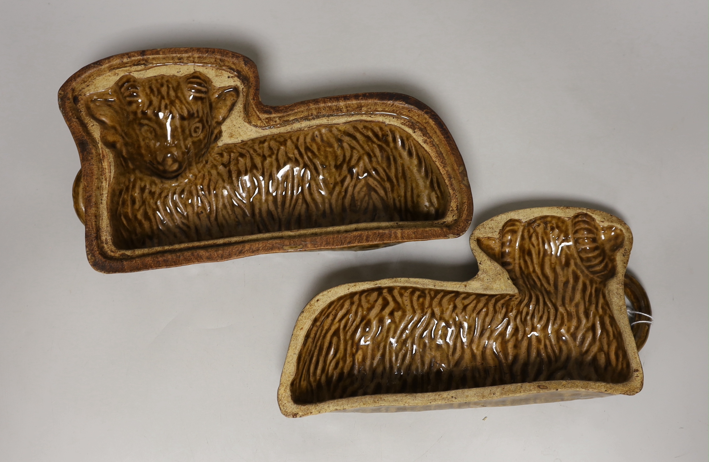 A 19th century lead glazed pottery 'lamb' baking mould, in two halves, 29cm wide